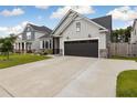 Lovely single-Gathering home with a spacious driveway, gray vinyl siding, dark garage door, and stone accents at 404 Omaha Dr, Moncks Corner, SC 29461
