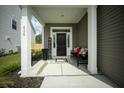 Inviting front porch with a black door, a welcome sign, and a bench with decorative pillows at 436 Rowley Ln, Summerville, SC 29486
