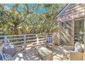 Relax on this serene deck with cozy furniture and shaded by mature trees at 4403 Sea Forest Dr, Kiawah Island, SC 29455