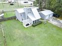 Aerial view of a home featuring a large manicured lawn, a detached garage and a cozy back patio at 49 Auld Brass Rd, Walterboro, SC 29488