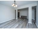 Open-concept living area with modern flooring, neutral walls, and a stylish chandelier at 5128 Thornton Dr, Summerville, SC 29485