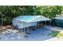 Exterior view of a metal outbuilding featuring two garage doors and a covered parking area for vehicles or equipment at 513 Pauline Dr, Bonneau, SC 29431