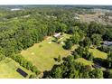 Expansive wooded property with a horse barn, paddock, and fenced training ring with solar panels nearby at 6434 Saint Anthony Dr, Meggett, SC 29449