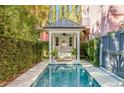 Secluded backyard pool featuring a charming cabana with a swing and lush greenery at 71 E Bay St, Charleston, SC 29401