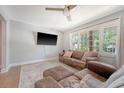 Comfortable living room with a plush sofa, decorative pillows, and large windows offering backyard views at 7639 Hillandale Rd, North Charleston, SC 29420
