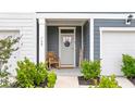 Charming front porch with rocking chair, welcome mat, and well-manicured landscaping at 768 Trotters Ln, Moncks Corner, SC 29461