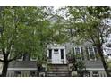 Charming home exterior with mature trees, white trim, and inviting front steps at 84 Bull St # F, Charleston, SC 29401