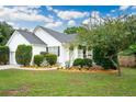 Charming single-story home with manicured landscaping, white siding and a welcoming front porch at 1077 Farmington Rd, Charleston, SC 29412