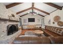 Inviting living room with a brick fireplace, wood beams, a comfortable leather sofa, and a wooden floor at 109 Lakeview Dr, Summerville, SC 29485