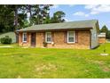 Quaint brick home with green roof, surrounded by lush landscaping at 109 Rahway Rd, Goose Creek, SC 29445