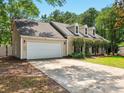 View of the home with a large garage and a long driveway at 113 Mapperton Ct, Summerville, SC 29485