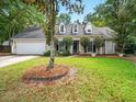 Inviting home with a well-maintained lawn, mature trees, and classic architecture at 113 Mapperton Ct, Summerville, SC 29485
