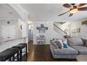 Open-concept living area with hardwood floors, a breakfast bar, gray sectional sofa, and ample natural light at 132 Daniels Ridge Dr, Summerville, SC 29485