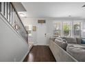 Inviting entryway with hardwood floors, stairs, and a spacious living area featuring a comfortable gray sectional sofa at 132 Daniels Ridge Dr, Summerville, SC 29485