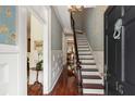 Elegant entryway with hardwood floors, blue floral wallpaper, and a staircase, offering a grand welcome at 16 Trumbo St, Charleston, SC 29401