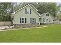 Well-maintained home with green siding, black shutters, and manicured landscaping at 189 Fox Chase Dr, Goose Creek, SC 29445