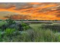 Scenic marsh view with a colorful sunset provides a tranquil and picturesque backdrop at 200 Wappoo Rd, Charleston, SC 29407