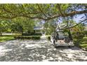 Charming home with a manicured front yard, mature trees, and a golf cart parked in the driveway at 2060 Wappoo Hall Rd, Charleston, SC 29412