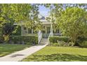 Inviting two-story home with a covered porch, manicured hedges, and a charming walkway leading to the front door at 2060 Wappoo Hall Rd, Charleston, SC 29412