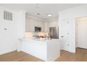 Well-lit kitchen boasts stainless appliances, white countertops, ample cabinet space, and hardwood flooring at 21 George St # 206, Charleston, SC 29401