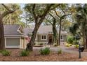 Inviting one-story home with a driveway, green lawn, beautiful landscaping, and a cozy curb appeal at 2105 Loblolly Ln, Seabrook Island, SC 29455
