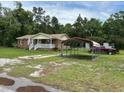 A brick single-story home with a covered porch and a metal carport beside it, set on a green lawn at 277 Carolina Cir, Walterboro, SC 29488