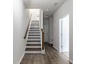 Modern entryway with wood-look flooring and staircase, showcasing bright, neutral tones at 304 Pathfinder Way, Charleston, SC 29492