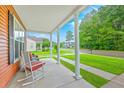 Relaxing front porch with white columns, comfortable rocking chairs, and a view of the neighborhood at 309 Harriswood Ln, Moncks Corner, SC 29461