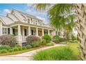 Beautiful home showcasing a covered front porch, professional landscaping, and inviting walkway at 4215 Ten Shillings Way, Ravenel, SC 29470