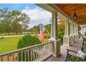 Scenic view from the porch featuring lush greenery, an American flag, and a tranquil atmosphere at 4215 Ten Shillings Way, Ravenel, SC 29470