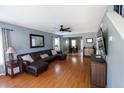 Cozy living room with hardwood floors, a leather sofa, ceiling fan, and access to the dining room at 5094 Thornton Dr, Summerville, SC 29485
