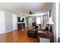 Spacious living room featuring hardwood floors, a leather sofa, ceiling fan, and front door at 5094 Thornton Dr, Summerville, SC 29485