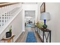 Bright entryway boasting hardwood floors, a staircase, and views into the kitchen and living room at 512 Alderly Dr, Moncks Corner, SC 29461