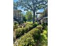 Exterior view of community buildings with mature trees, green grass, and flowerbeds at 516 Arlington Dr # B5, Charleston, SC 29414
