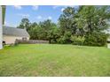 Expansive backyard featuring a lush lawn, mature trees, and a privacy fence at 520 Crossland Dr, Moncks Corner, SC 29461