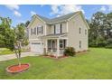 Charming two-story home featuring a cozy front porch, well-maintained lawn, and attached two-car garage at 520 Crossland Dr, Moncks Corner, SC 29461