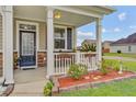 Inviting front porch with decorative railing, beautiful flower boxes, and a stone-accented facade at 520 Crossland Dr, Moncks Corner, SC 29461