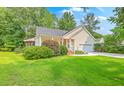 Inviting one-story home with a manicured lawn, covered porch, and attached garage at 5347 Sundial Ct, North Charleston, SC 29418