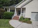 A charming front porch featuring brick steps, white railings, and views of the landscaped garden at 5347 Sundial Ct, North Charleston, SC 29418