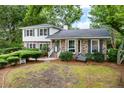 Traditional two-story home with a brick facade, mature trees, and green shutters at 886 Friendly Cir, Charleston, SC 29414