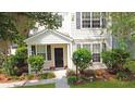 Two-story home featuring black shutters, manicured bushes, and a well-maintained lawn with mature trees at 8967 N Red Maple Cir, Summerville, SC 29485