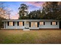 Charming one-story home boasts a freshly painted exterior and manicured front lawn with colorful sunset hues at 907 Pauline Ave, Charleston, SC 29412