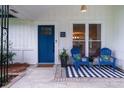 Inviting front porch with blue chairs, a black and white rug, and a stylishly painted blue front door at 103 Four Iron Dr, Summerville, SC 29483