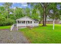 Classic single-story home with a covered porch, features a grassy front yard and mature trees at 106 N Pine St, Summerville, SC 29483