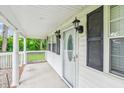 Covered front porch features black sconce lighting, white railing, and decorative white door at 106 N Pine St, Summerville, SC 29483