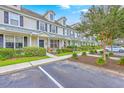 A row of cozy townhomes featuring well-kept lawns and inviting porches, complemented by mature trees at 108 Hemingway Cir, Summerville, SC 29483