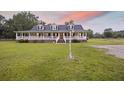Charming exterior of home with white pillars, covered porch, and well-maintained lawn at dusk at 117 Ponderosa Rd, Summerville, SC 29483