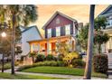 Inviting two-story home with well-manicured lawn, a welcoming porch, and fresh landscaping at 134 Etiwan Park St, Charleston, SC 29492