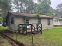 Simple single-story home showcasing a wooden deck, weathered exterior and minimal landscaping in the backyard at 137 Droze Rd, Summerville, SC 29483