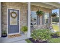 Inviting front porch with stone accents, seating area, and seasonal decorations at 165 Clydesdale Cir, Summerville, SC 29486